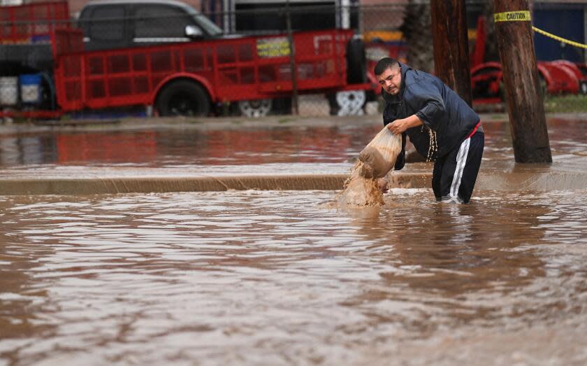 Ensenada, Mexico August 19, 2023-A man tries to clear a drain as Tropical Storm Hilary makes landfall in Ensenada, Mexico Sunday.`(Wally Skalij/Los Angles Times)