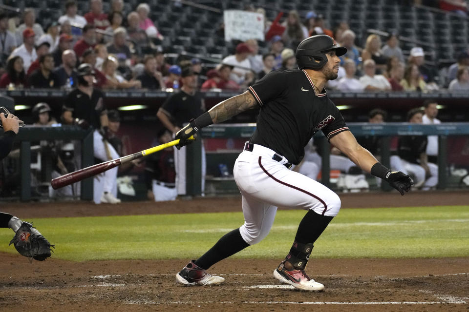 Arizona Diamondbacks' David Peralta hits an RBI ground rule double against the San Francisco Giants in the fourth inning of a baseball game, Wednesday, July 27, 2022, in Phoenix. (AP Photo/Rick Scuteri)