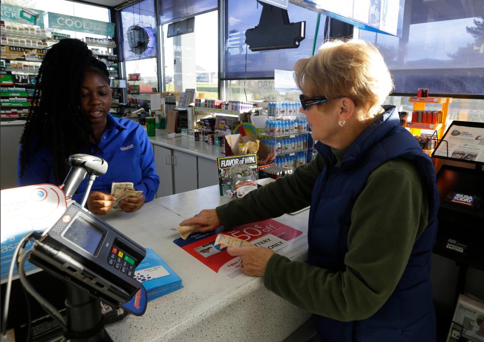 Julie Egan of the Town of Brookfield buys lottery tickets at Pewaukee Corner Pump last year when the Mega Millions jackpot was about $1.6 billion, the largest jackpot in U.S. history.