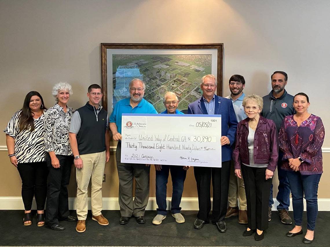 L.E. Schwartz employees present a check to the United Way in 2021. The business has been a contributor to the United Way for several years.