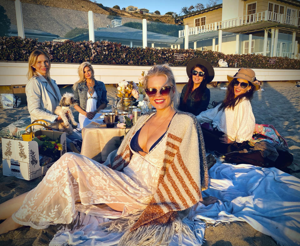 This photo shows Shivaune Field, center, with friends, background from left, Jessica Jackson, Dr. Courtney McCaul, Nicole Bentley and Shannon Nichols celebrating Field's 41st birthday on Carbon Beach in Malibu, Calif., on Jan. 16, 2021. Last year, Shivaune Field celebrated her birthday with a small group of friends at a downtown restaurant in Los Angeles. This year, when she turned 41, she took to the beach with her pals. (Gerald W Brunskill via AP)