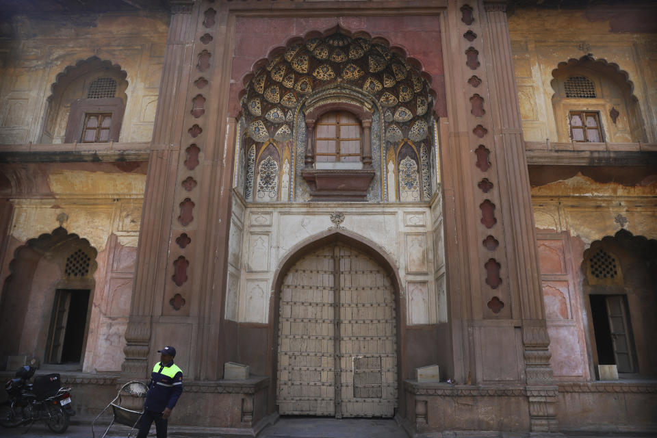 A private security guard walks past the gate of Safdarjung's Tomb, a sandstone and marble mausoleum built in 1754, closed as a precaution against the spreading of new coronavirus in New Delhi, India, Tuesday, March 17, 2020. For most people, the new coronavirus causes only mild or moderate symptoms. For some, it can cause more severe illness, especially in older adults and people with existing health problems. (AP Photo/Manish Swarup)
