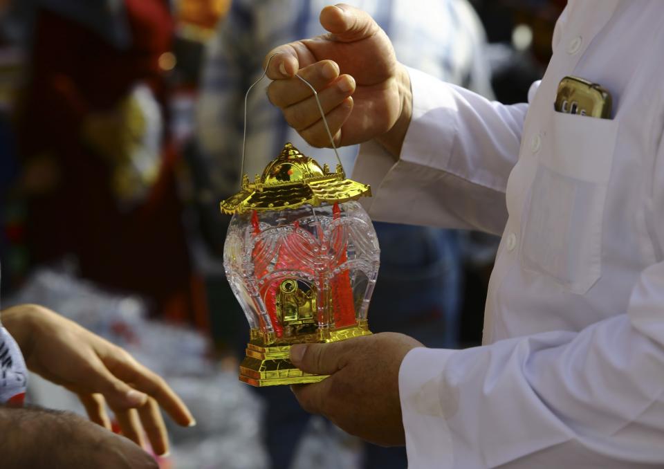 <p>An elderly man checks a traditional Ramadan lantern before buying it to mark the holy month of Ramadan at the main market in Gaza City, May 25, 2017. (AP Photo/Adel Hana) </p>