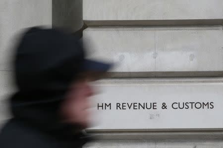 FILE PHOTO: A pedestrian walks past the headquarters of Her Majesty's Revenue and Customs (HMRC) in central London, Britain February 13, 2015. REUTERS/Stefan Wermuth/File Photo