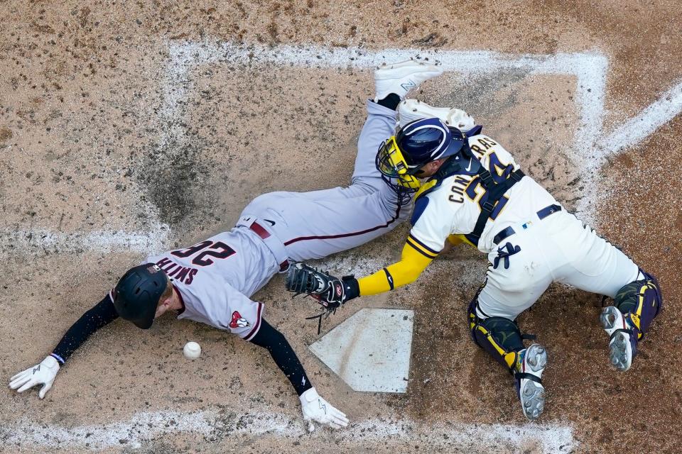 Arizona Diamondbacks' Pavin Smith scores as Milwaukee Brewers' William Contreras can't hold on to the ball during the sixth inning of a baseball game Wednesday, June 21, 2023, in Milwaukee. (AP Photo/Morry Gash)