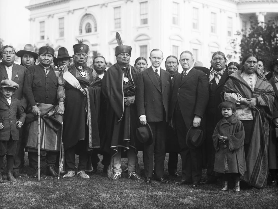 Osage Indians in Washington were introduced to the President on Saturday by Indian Commissioner Burke regarding their oil areas in Oklahoma. The Osage Indians are the wealthiest tribe in the United States. The photo shows the Indians posing with President Coolidge.