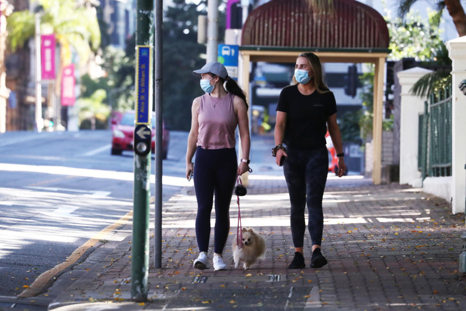 Two women walk while wearing masks in Brisbane CBD on Sunday. Source: AAP