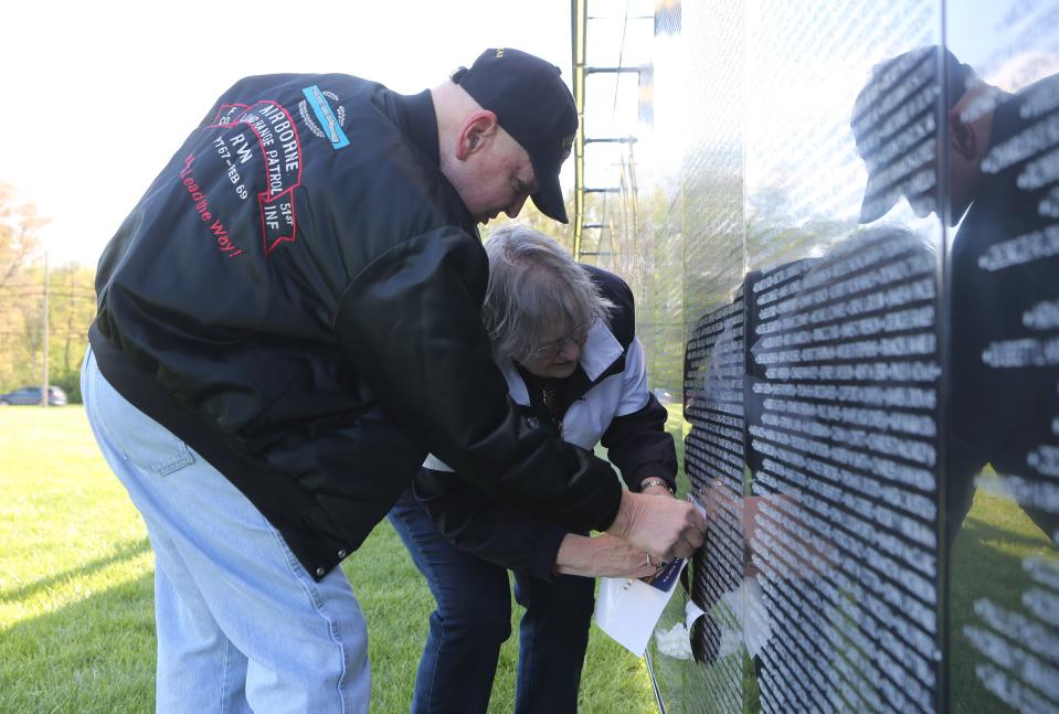 Thomas and Suzanne Grzybowski, of New Castle, take a rubbing of Michael DiPasquantonio's name from The Wall That Heals Thursday morning near New Castle.  Thomas grew up with DiPasquantonio, who was killed in the Vietnam War, in Wilmington's Browntown area.