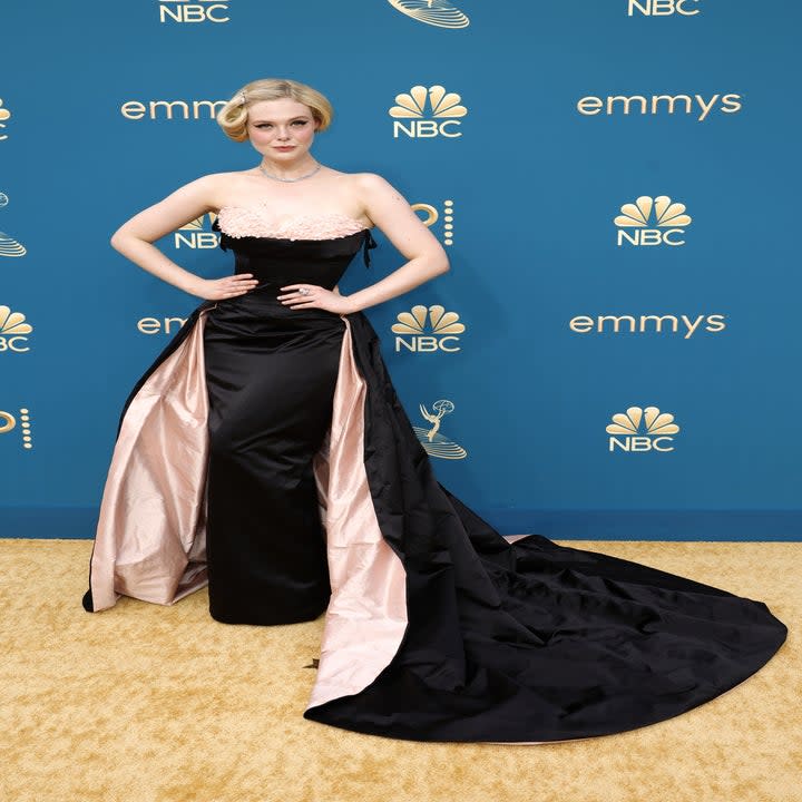 Elle Fanning wearing a black and pink gown with a train