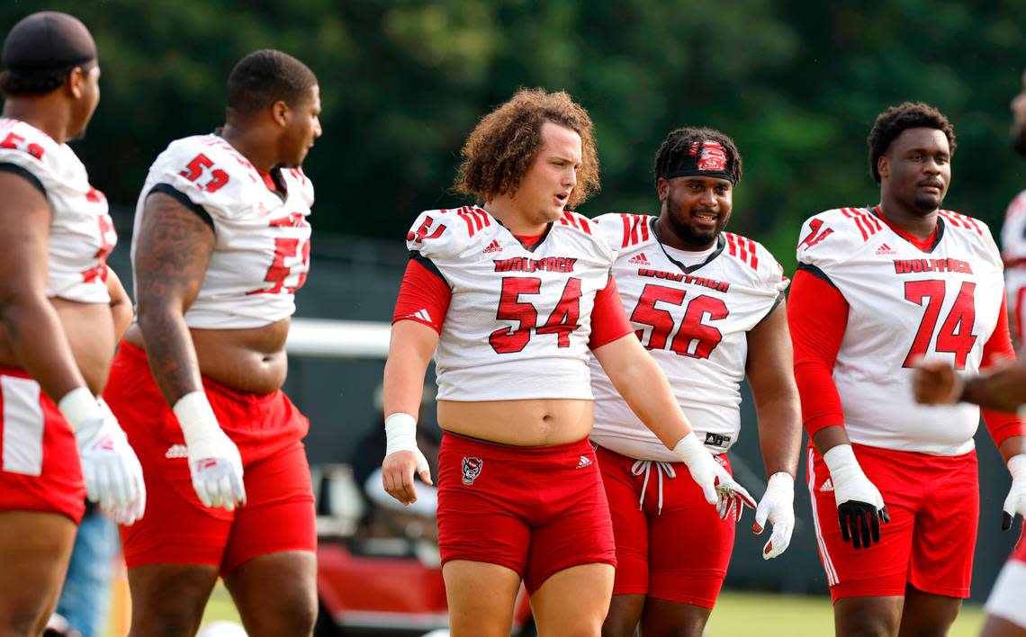The N.C. State offensive line, from left, Timothy McKay (52), Derrick Eason (53), Dylan McMahon (54), Lyndon Cooper (56) and Anthony Belton (74) prepare to run a drill during the Wolfpack’s first fall practice in Raleigh, N.C., Wednesday, August 2, 2023. Ethan Hyman/ehyman@newsobserver.com