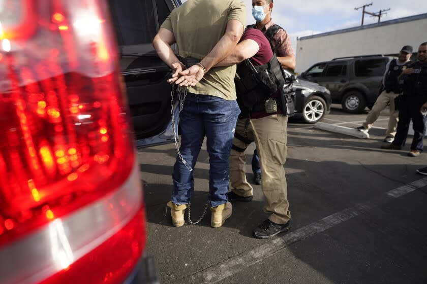 U.S. Immigration and Customs Enforcement agents transfer an immigrant after an early morning raid in Duarte, Calif., Monday, June 6, 2022. This weekend, the Biden administration said it would suspend an order prioritizing the arrest and deportation of immigrants considered a threat to public safety and national security in order to comply with a ruling earlier in June 2022 from a Texas judge. (AP Photo/Damian Dovarganes)