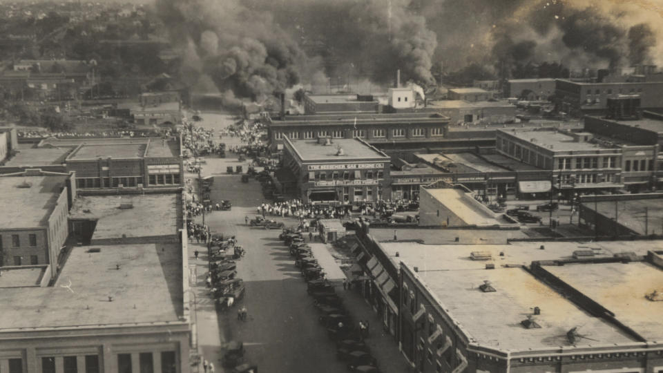 This photo provided by Department of Special Collections, McFarlin Library, The University of Tulsa shows crowds of people watching fires during the June 1, 1921, Tulsa Race Massacre in Tulsa, Okla. (Department of Special Collections, McFarlin Library, The University of Tulsa via AP)