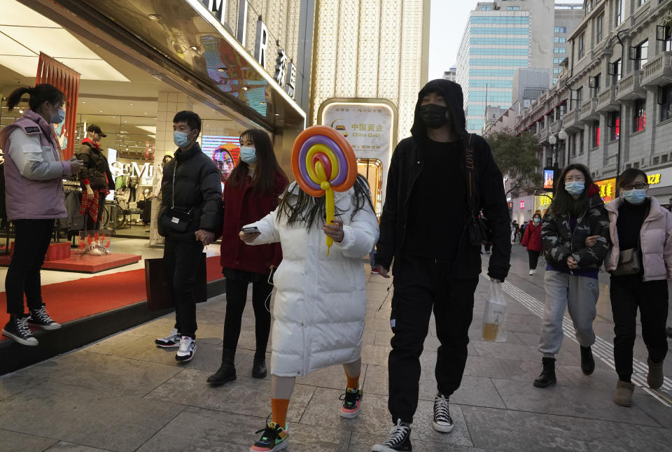 Varias personas pasean por las calles de Wuhan. Pese a que durante semanas el uso de mascarillas se redujo, la aparición de contagios en el país ha hecho que vuelvan a estar muy presentes.(AP Photo/Ng Han Guan)