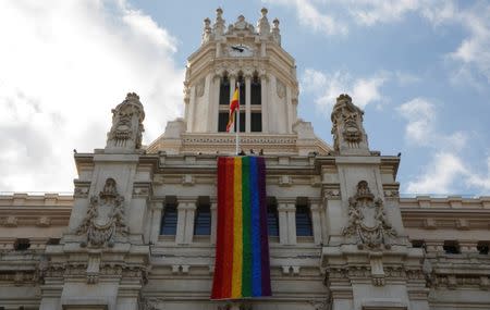 A giant rainbow flag hangs over the facade of city hall after being unfurled in Madrid, Spain, June 26, 2017. REUTERS/Sergio Perez