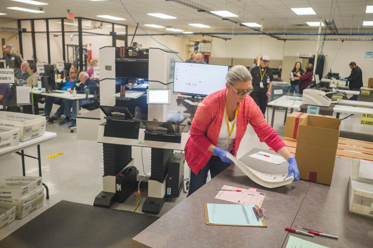An election worker, watched by observers from both major political parties, handles 2022 midterm ballots in Phoenix, Ariz. <a href="https://www.gettyimages.com/detail/news-photo/poll-worker-handles-ballots-for-the-midterm-election-in-the-news-photo/1244223114" rel="nofollow noopener" target="_blank" data-ylk="slk:Olivier Touron/AFP via Getty Images;elm:context_link;itc:0;sec:content-canvas" class="link ">Olivier Touron/AFP via Getty Images</a>