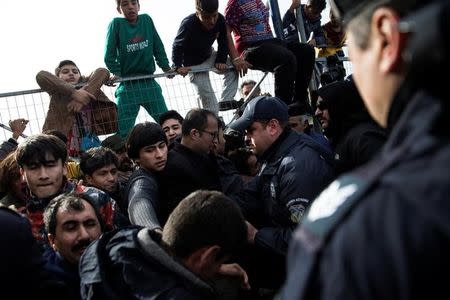 Refugees and migrants, most of them Afghans, block the entrance of the refugee camp at the disused Hellenikon airport as police officers try to disperse them, in Athens, Greece, February 6, 2017. REUTERS/Alkis Konstantinidis