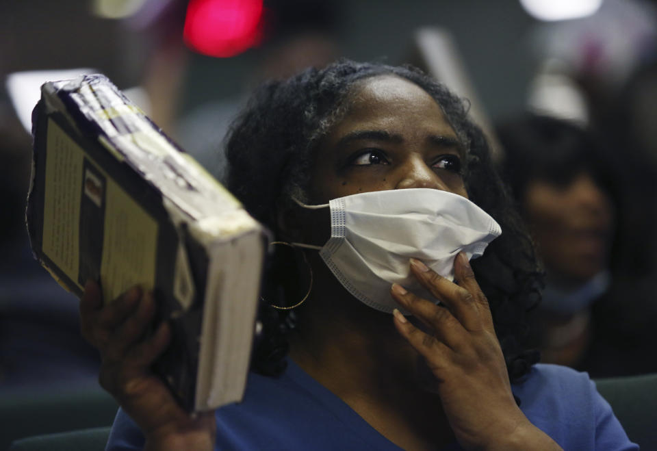 Constance Law holds a bible and a face mask as she worships with fellow congregants in Bluefield, W.Va, on Saturday, Jan. 24, 2021. (AP Photo/Jessie Wardarski)