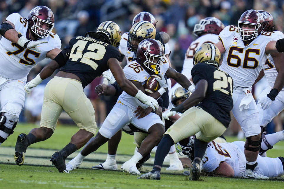 Minnesota running back Zach Evans (26) cuts between Purdue linebacker Clyde Washington (42) and defensive back Sanoussi Kane (21) during the first half of an NCAA college football game in West Lafayette, Ind., Saturday, Nov. 11, 2023. (AP Photo/Michael Conroy)
