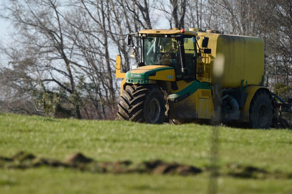 FILE: A tractor pulling a tank full of soil amendment sprays the ground at a farm near Warren County, Ga., on Jan. 26, 2023. The soil additive has become a hotly contested issue in rural areas of east Georgia, and legislation is hoping to create more local control for counties to regulate the industry.