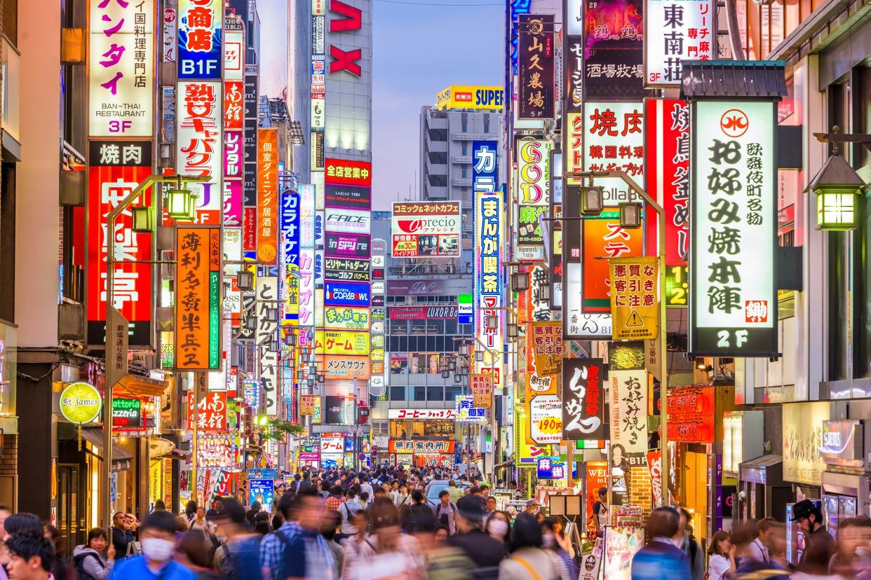 crowds pass through Kabukicho in the Shinjuku district in Tokyo, Japan