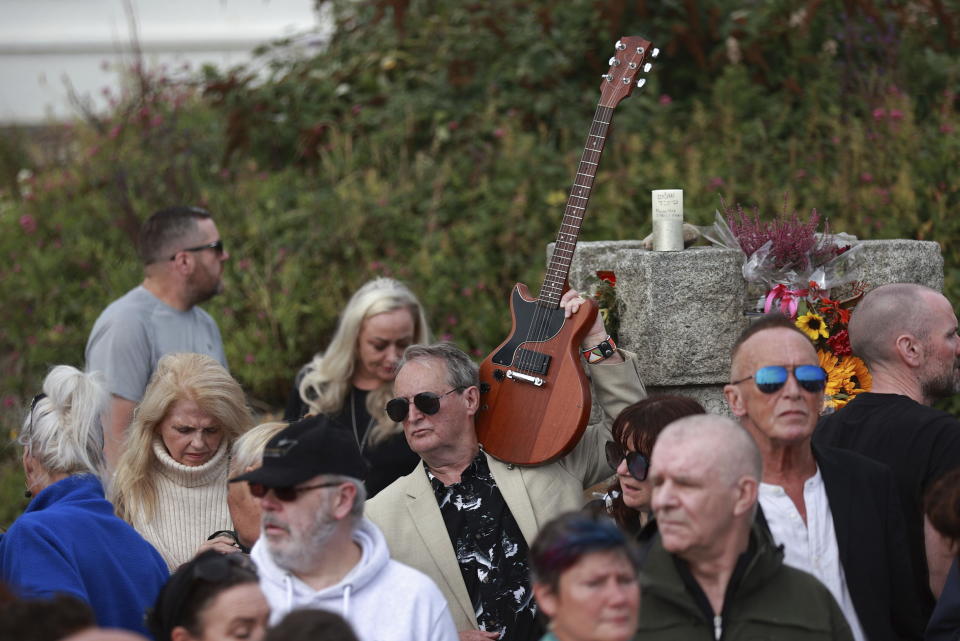 Fans gather outside the former home of Sinead O'Connor ahead of the late singer's funeral, in Bray, Co Wicklow, Ireland, Tuesday, Aug. 8, 2023. O’Connor’s family has invited the public to line the waterfront in Bray on Tuesday as her funeral procession passes by. Fans left handwritten notes outside her former home, thanking her for sharing her voice and her music. (Liam McBurneyPA via AP)