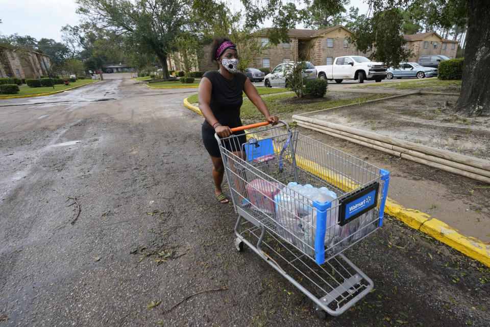 Fanchiskia Gulley moves toward her apartment after purchasing provisions in the aftermath of Hurricane Sally, Friday, Sept. 18, 2020, in Fla. (AP Photo/Gerald Herbert)