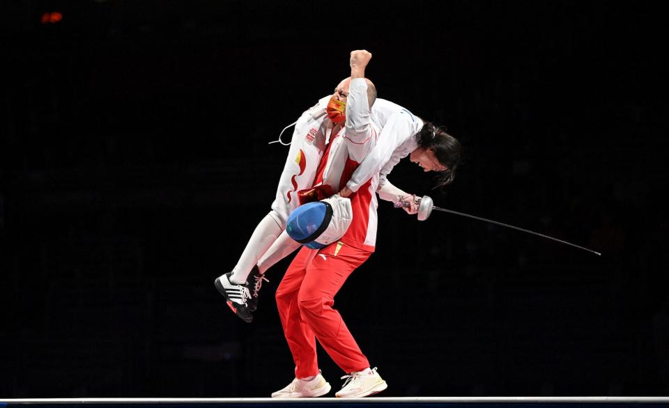 Sun Yiwen is carried over the shoulder of her coach after winning gold for China.
