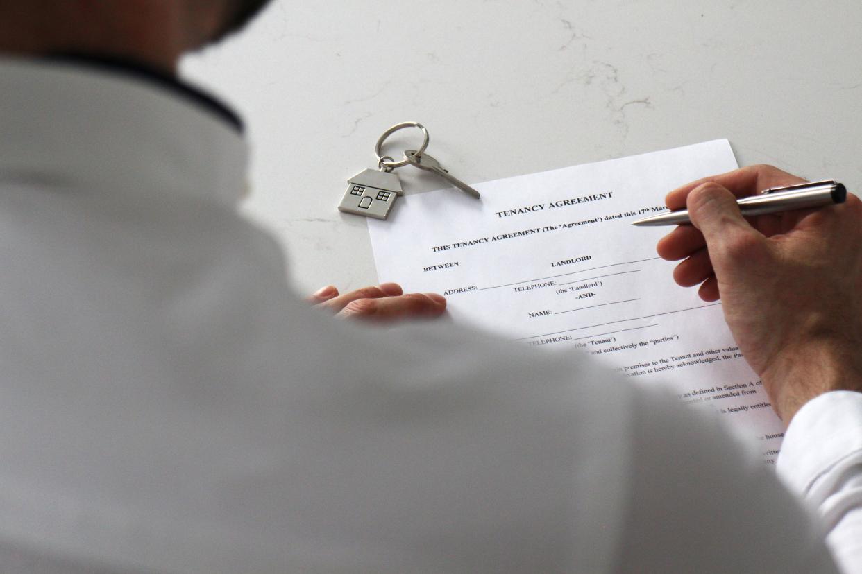 man filling out paperwork for tenancy agreement