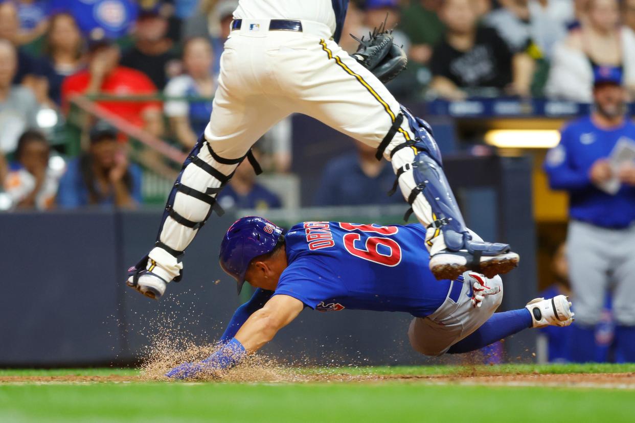 Cubs designated hitter Rafael Ortega slides under the tag of Brewers catcher Victor Caratini during the sixth inning Tuesday night at American Family Field.