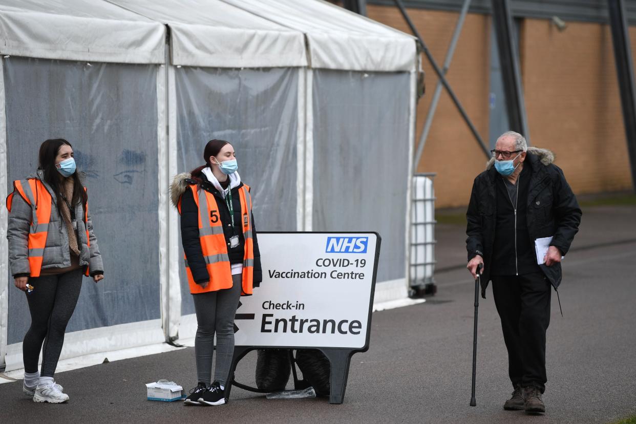 <p>Un hombre pasa junto a los voluntarios en un centro de vacunación temporal establecido para administrar una vacuna Covid-19, en el Colchester Community Stadium en Colchester, Essex, sureste de Inglaterra el 6 de febrero de 2021. - La Universidad de Oxford de Gran Bretaña dijo el viernes a sus investigadores detrás de la La vacuna conjunta AstraZeneca Covid-19 demostró ser eficaz contra la variante británica más contagiosa del virus, que surgió por primera vez en el sureste de Inglaterra a finales de septiembre y desde entonces se ha convertido en la cepa más común detectada en nuevas infecciones del Reino Unido, y se ha extendido a decenas otros paises. </p> (Foto de DANIEL LEAL-OLIVAS / AFP vía Getty Images)