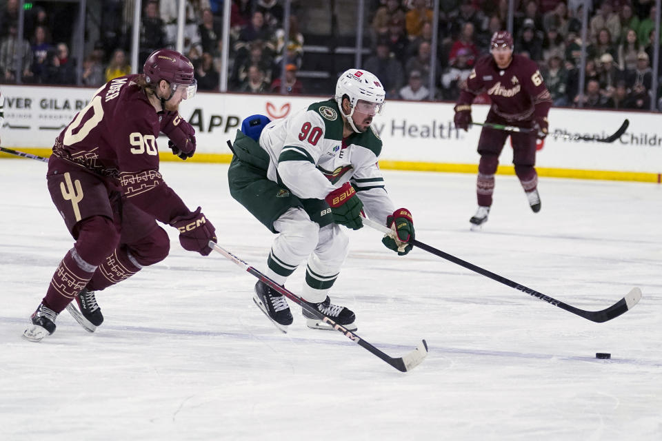 Minnesota Wild's Marcus Johansson (90) controls the puck against Arizona Coyotes' J.J. Moser (90) during the second period of an NHL hockey game Wednesday, Feb. 14, 2024, in Tempe, Ariz. (AP Photo/Darryl Webb)