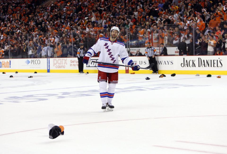 New York Rangers' Dominic Moore skates around the ice as fans throw hats for Philadelphia Flyers' Wayne Simmonds after Simmonds' hat trick during the second period in Game 6 of an NHL hockey first-round playoff series, Tuesday, April 29, 2014, in Philadelphia. (AP Photo/Chris Szagola)