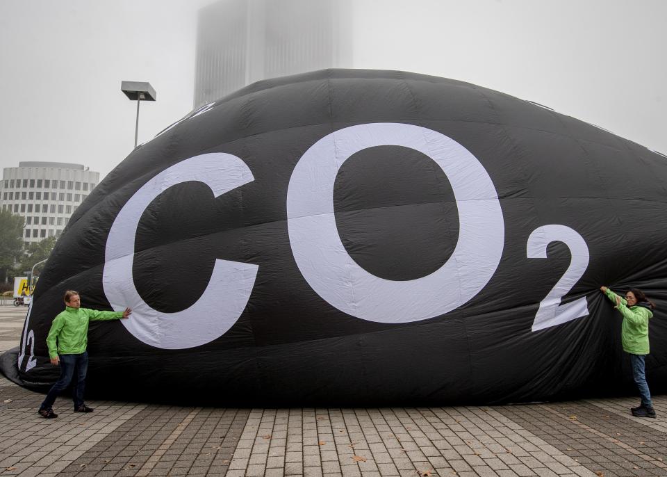 Activists of the environment protection organization 'Greenpeace' pump up a giant ballon to protest against climate-damaging cars displayed at the IAA Auto Show in Frankfurt, Germany, Tuesday, Sept. 10, 2019. (AP Photo/Michael Probst)