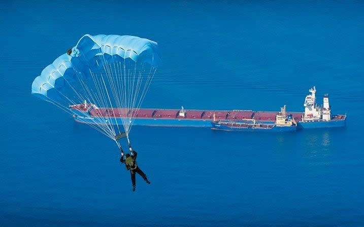 A member of the Submarine Parachute Assistance Group (SPAG) jumps into the bay of Gibraltar during an annual training exercise. - Crown Copyright