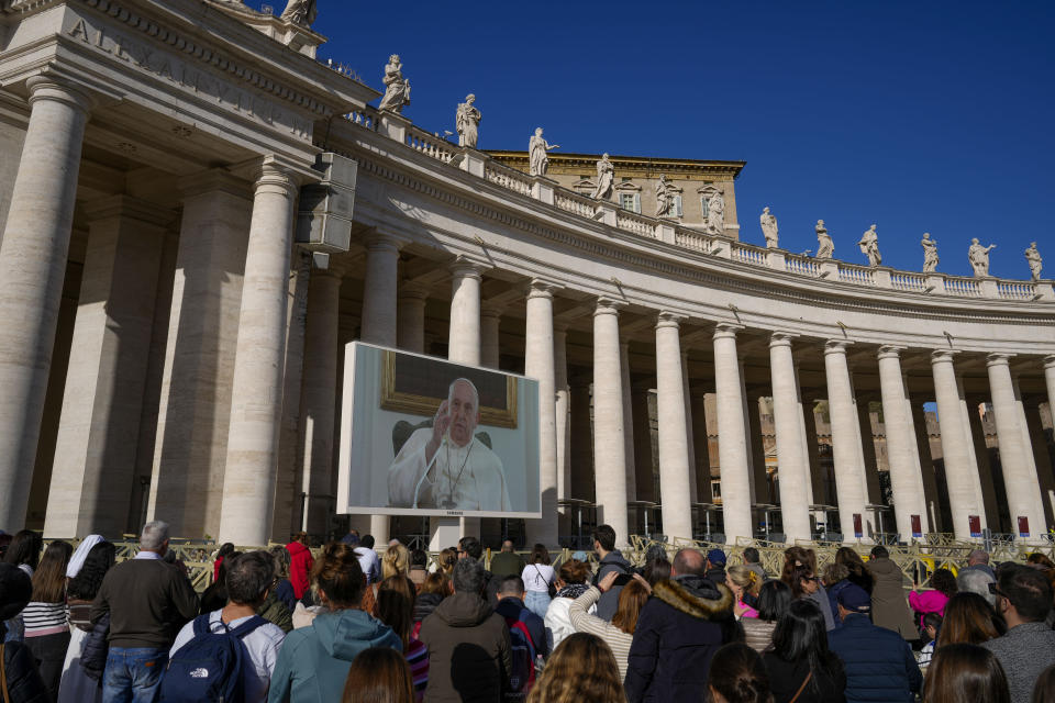 Pope Francis appears on a giant monitor set up in St. Peter's Square at The Vatican, Sunday, Dec. 3, 2023, as he blesses the faithful gathered in the square for the traditional Angelus noon prayer. Francis skipped his weekly Sunday appearance at a window because suffering from a mild flu. (AP Photo/Andrew Medichini)