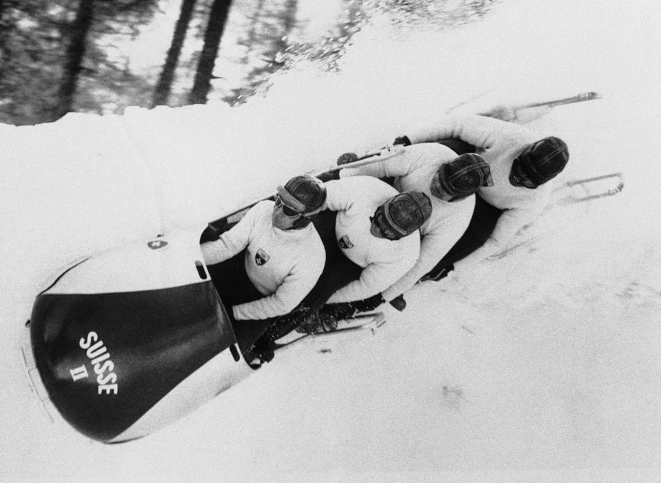 FILE - In this Feb. 4, 1956, file photo, a shower of snow and ice from the number two Swiss bobsled sprays over the banked edge of the bumpy Olympic bobsled course of Cortina D'Ampezzo, Italy, as Max Angst battles for control of the speeding four-man sled. The Cortina track was built in 1923 and the resort known as the “Queen” of the Italian Dolomites was home to bobsledding great Eugenio Monti, who won six Olympic medals between 1956 and 1968. (AP Photo/Jim Pringle, File)