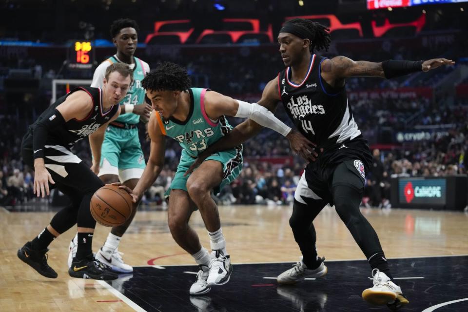 Clippers guard Terance Mann, right, defends against San Antonio Spurs guard Tre Jones.