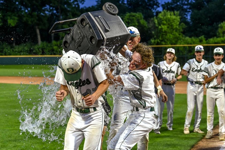 Olivet's Cam Frazier, left, is doused with water from teammate Caiden Giguere, right, after Frazier was named MVP after the Eagles beat Grand Ledge to win the Diamond Classic title on Monday, June 5, 2023, at McLane Stadium on the Michigan State University campus in East Lansing.