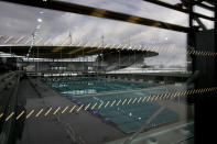 The Stade de France stadium is reflected on the window of the Olympic Aquatic Center, Wednesday, March 6, 2024 in Saint-Denis, outside Paris. The aquatic center will host the artistic swimming, water polo and diving events during the Paris 2024 Olympic Games. (AP Photo/Christophe Ena, File)