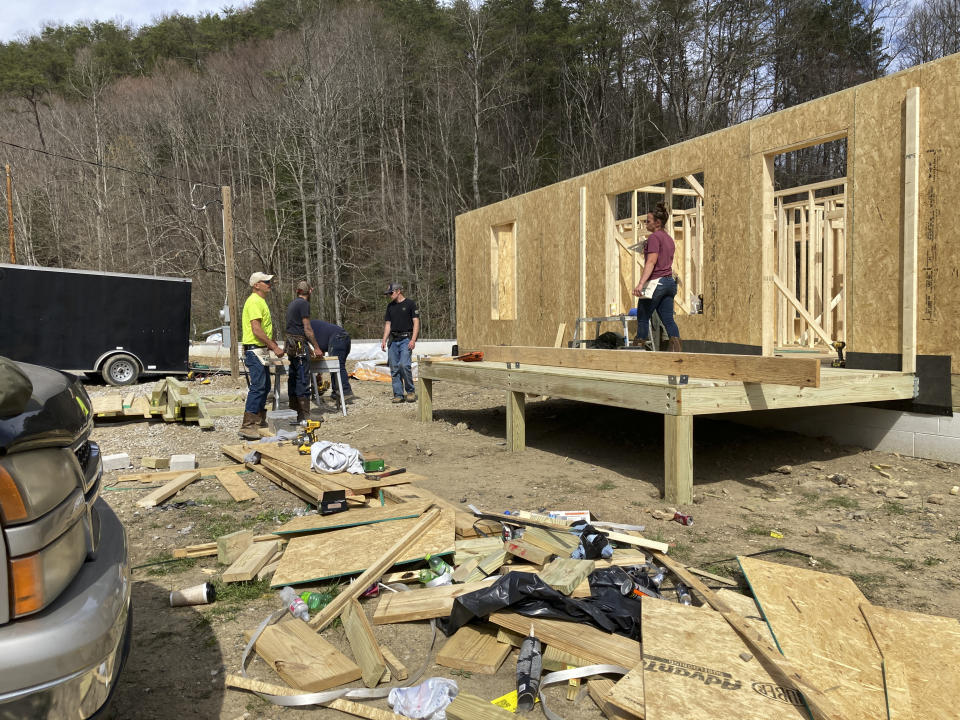 Construction workers build a house for a displaced flood victim in Jackson, Ky, on Wednesday, March 29, 2023. The Housing Development Alliance, a nonprofit, is building seven new houses on the street, which is located on higher ground safe from flooding risk. (AP Photo/Dylan Lovan)