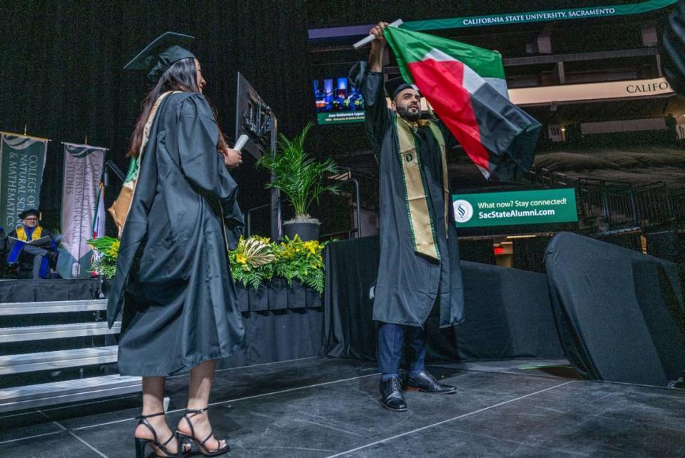 Mohammad Ilyas Ahmadzai, a masters degree graduate in the school of business, unfurls a Palestinian flag after receiving his diploma at the Sacramento State commencement ceremony at Golden 1 Center on Friday.