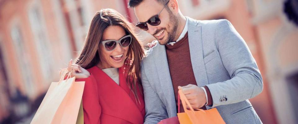 Beautiful young loving couple carrying shopping bags and enjoying together.