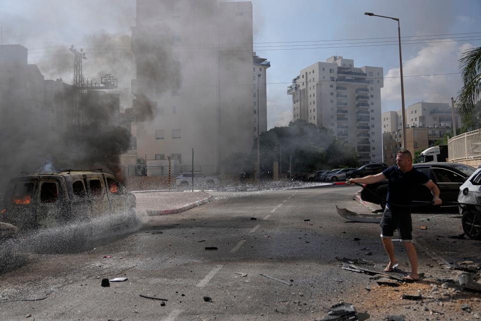 Cars are on fire after they were hit by rockets from the Gaza Strip in Ashkelon, Israel, on Saturday, Oct. 7, 2023. Palestinian militants in the Gaza Strip infiltrated Saturday into southern Israel and fired thousands of rockets into the country while Israel began striking targets in Gaza in response.