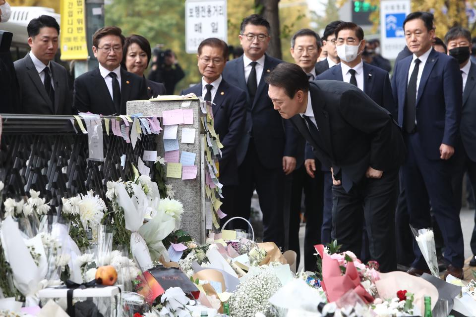 South Korean president Yoon Suk-yeol reads messages written by mourners while paying tribute to the victims of the Halloween celebration stampede, on the street near the scene on 1 November 2022 in Seoul, South Korea (Getty Images)