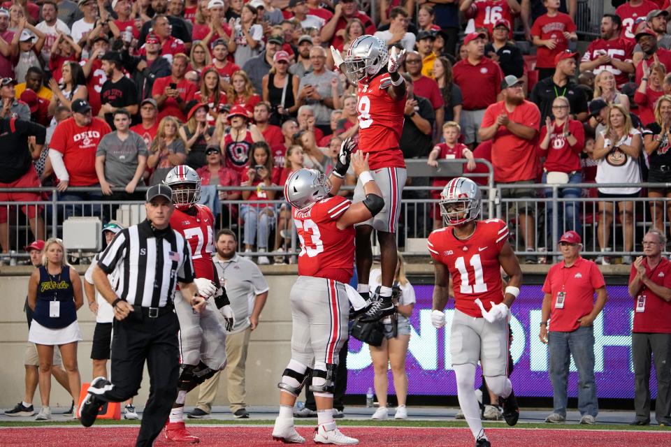 Ohio State center Luke Wypler tosses receiver Marvin Harrison Jr. into the air after Harrison Jr. scored a touchdown last week against Toledo.