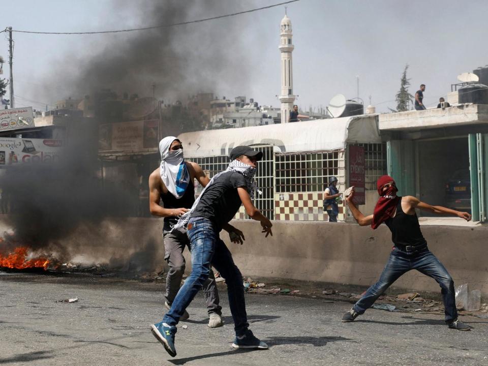 Palestinian protesters hurl stones towards Israeli troops during the violence (Reuters)