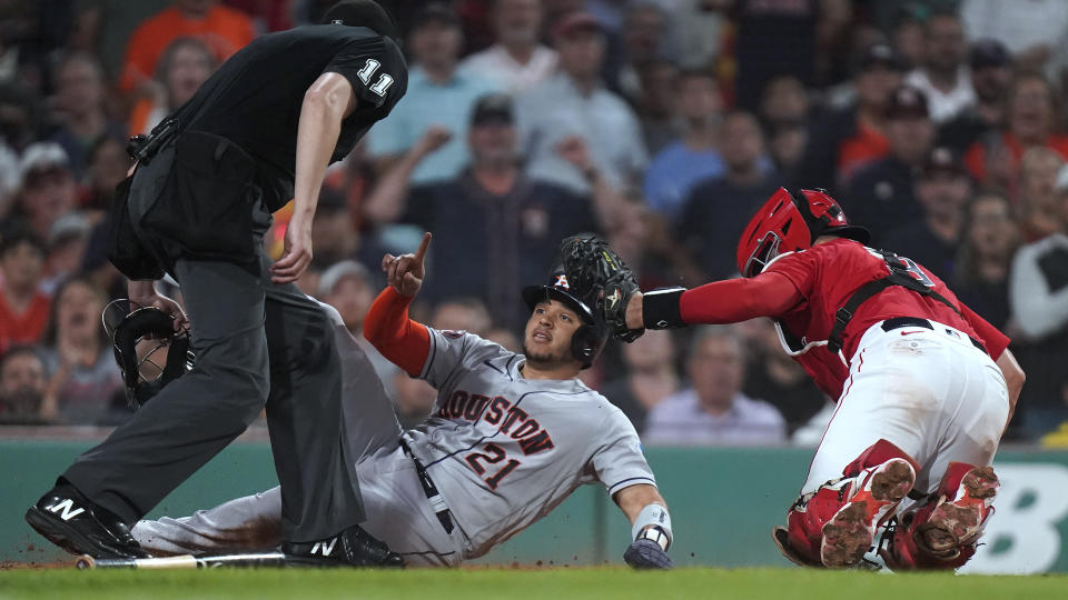 Houston Astros' Yainer Diaz (21) gestures after scoring on a two-run double by Mauricio Dubon, next to Boston Red Sox catcher Reese McGuire during the sixth inning of a baseball game Tuesday, Aug. 29, 2023, in Boston. (AP Photo/Steven Senne)