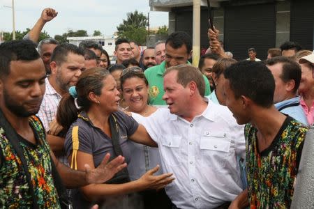 Juan Pablo Guanipa (C), candidate of the Venezuelan coalition of opposition parties (MUD) for the Zulia state governor office, greets supporters after casting his vote during a nationwide election for new governors in Maracaibo, Venezuela, October 15, 2017. REUTERS/Isaac Urrutia