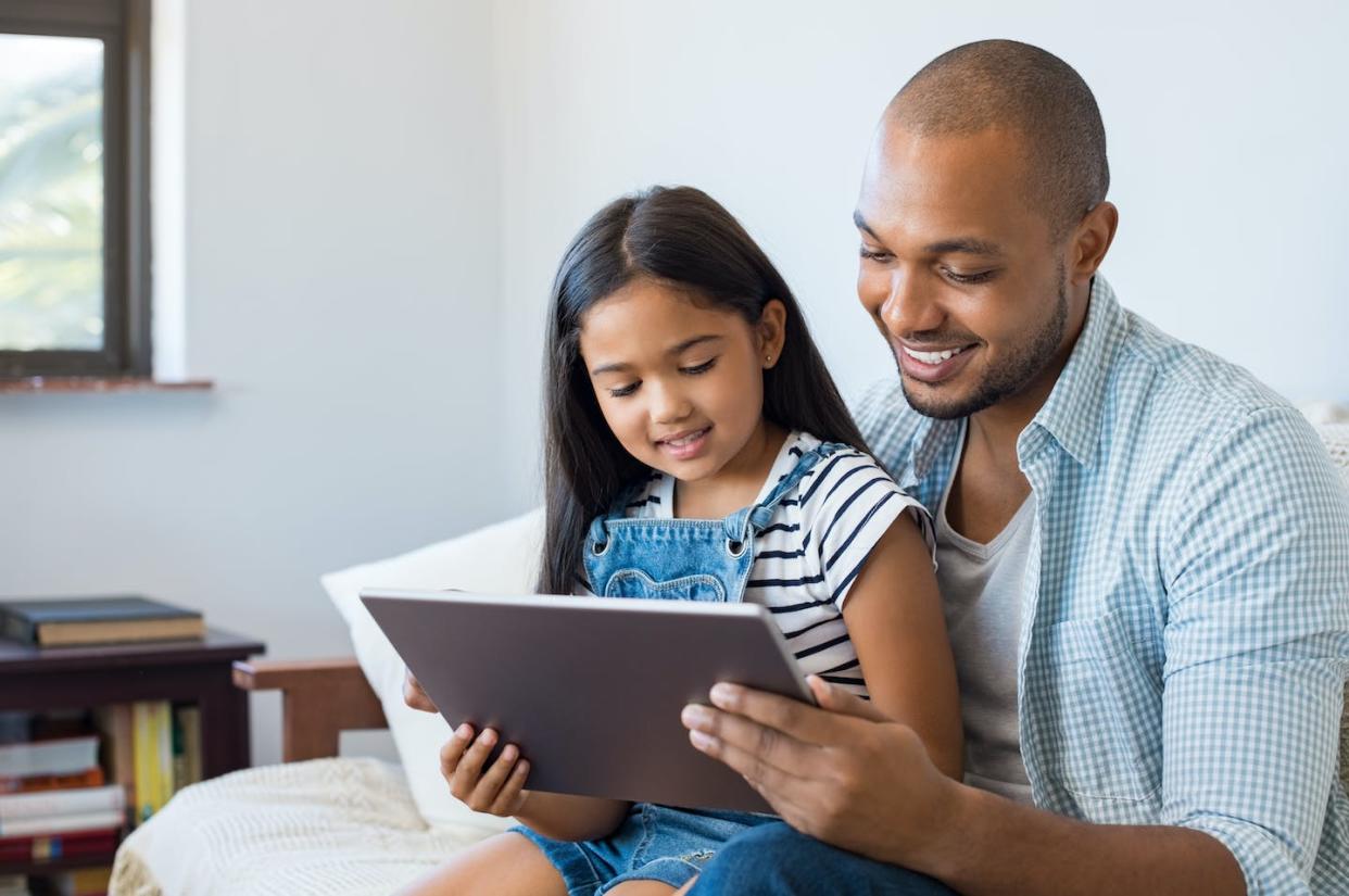Parents can model good media habits, like using online tools to connect with family and friends. <a href="https://www.gettyimages.com/detail/photo/father-and-daughter-using-tablet-royalty-free-image/696315038" rel="nofollow noopener" target="_blank" data-ylk="slk:Ridofranz/iStock/Getty Images Plus;elm:context_link;itc:0;sec:content-canvas" class="link ">Ridofranz/iStock/Getty Images Plus</a>