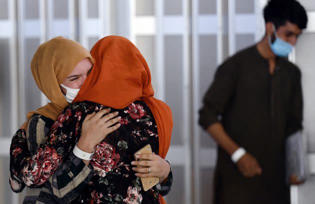 A woman embraces her sister-in-law (L) as she arrives with other Afghan refugees at Dulles International Airport on Aug. 23. (Photo: OLIVIER DOULIERY via Getty Images)
